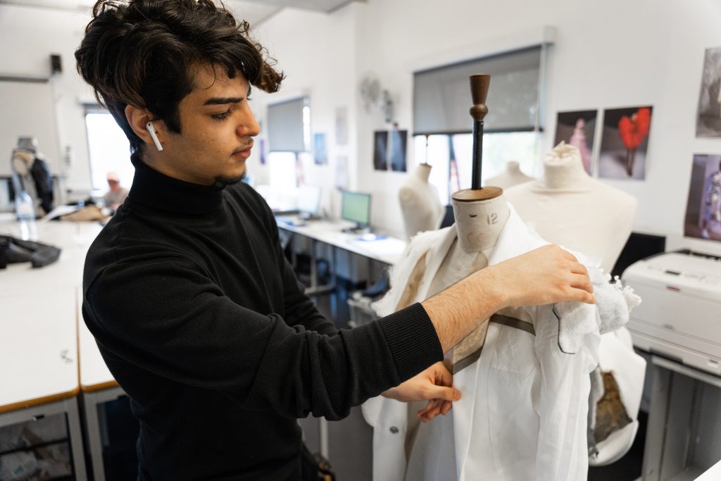 Young man in fashion studio working on creation