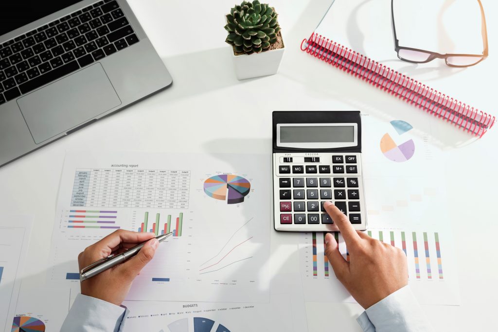 businesswoman working on desk using calculator and laptop 