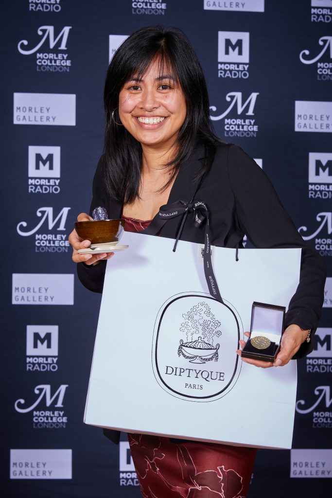 Staff member holding up awards given at the Morley Awards 2024