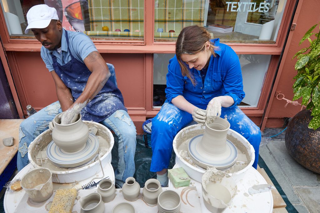 two people playing with clay