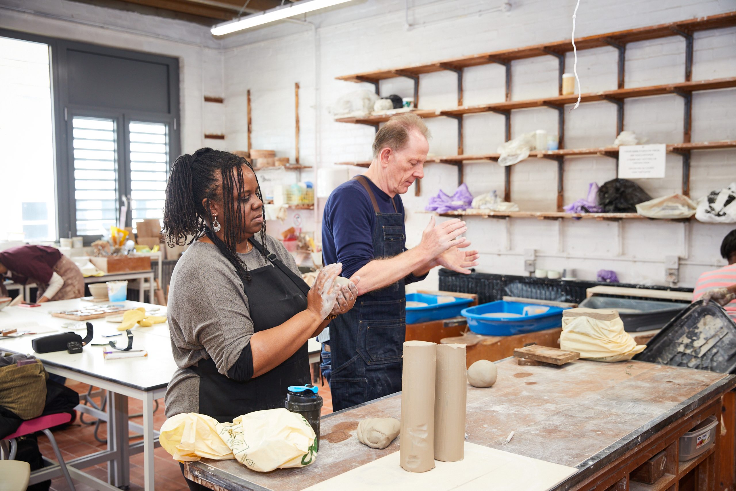 Black women and white man in ceramics studio