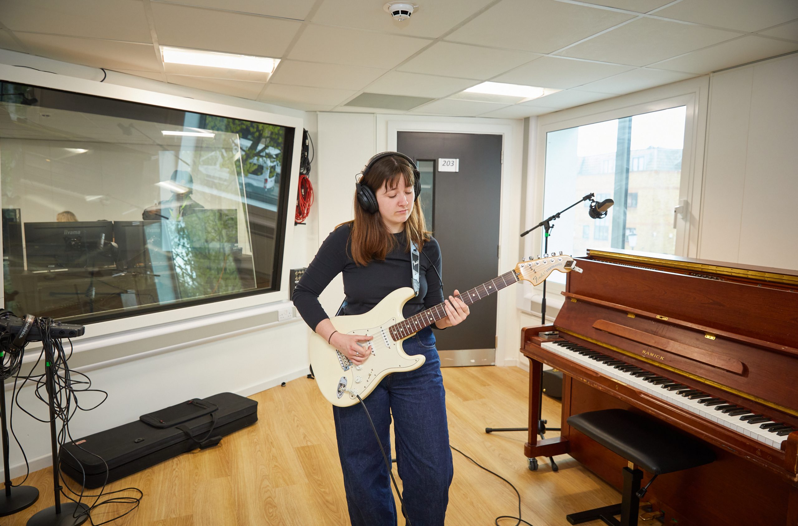 Girl playing guitar in recording studio