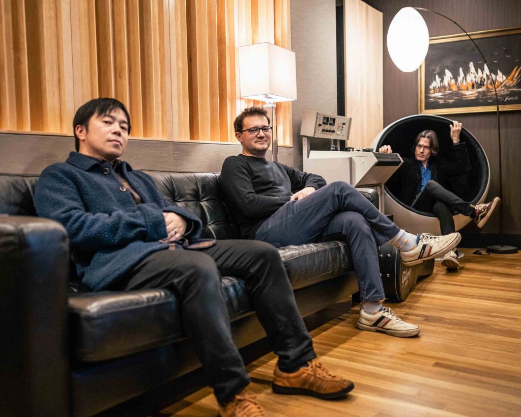 three men sitting on sofa